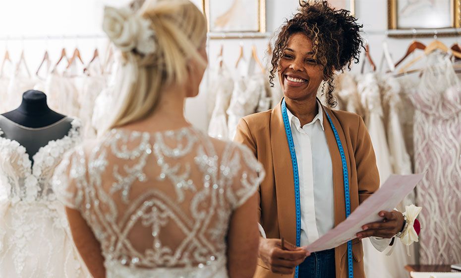 A bride in a shop talking to the shopkeeper about cardless payments