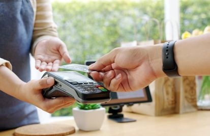 merchant helping customer with credit card reader